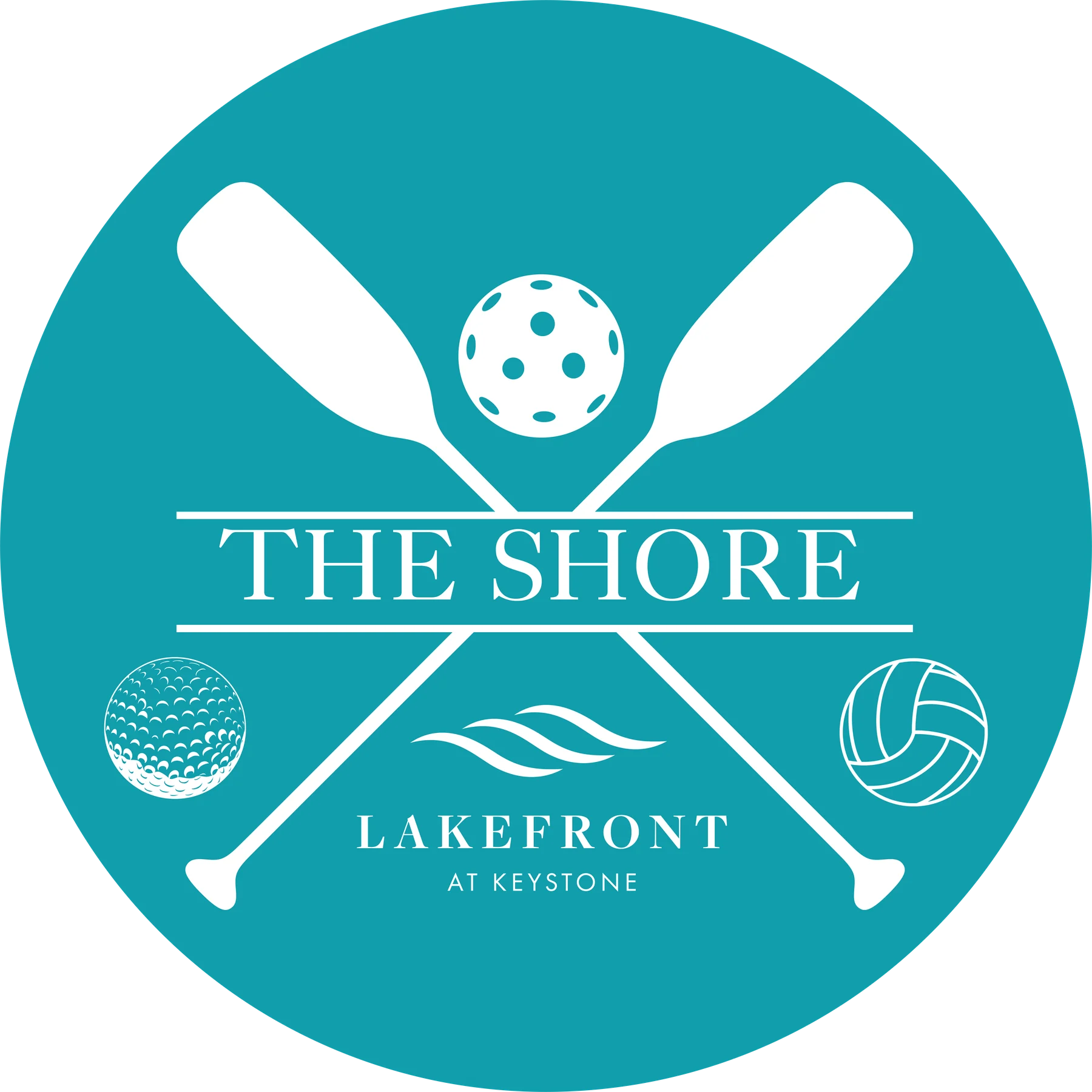 Teal circular logo for The Shore Lakefront at Keystone with crossed paddles and sport balls.